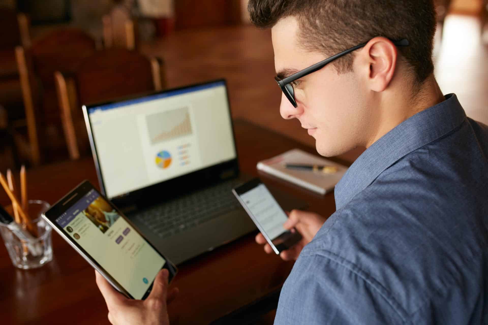 Man works at a desk, managing devices for seamless omnichannel marketing.
