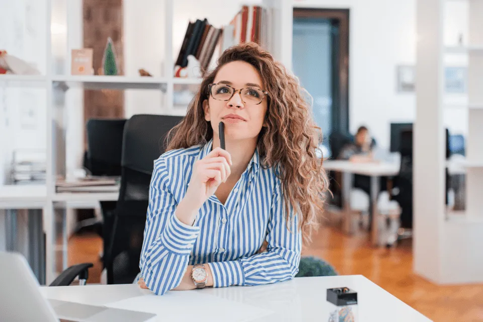 Striped-shirt person pondering email re-engagement strategy at their desk.