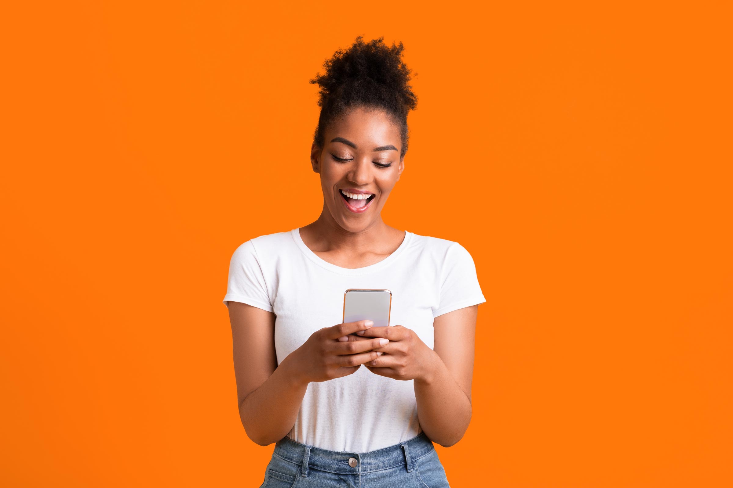 Woman smiling at her smartphone, showcasing storytelling in marketing.