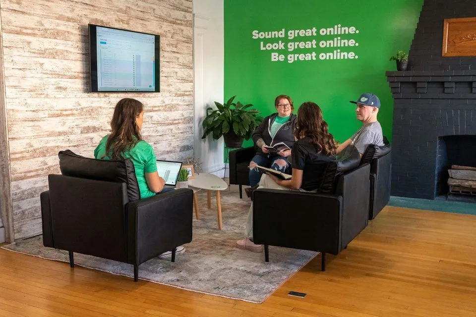 Four people sitting in a living room, having a casual meeting.