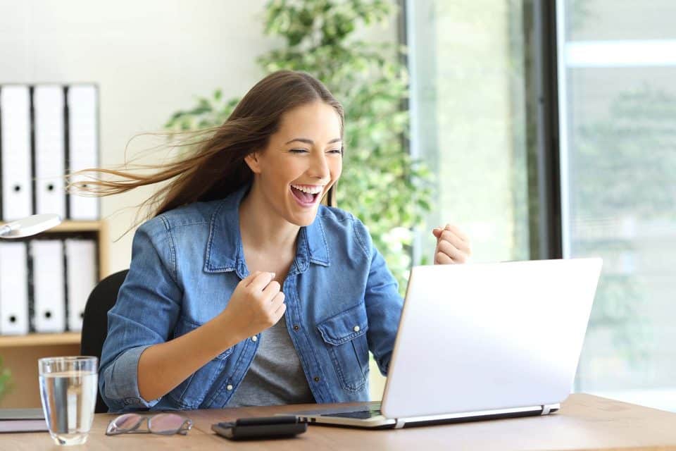 Person smiling and raising fists in excitement while reading a marketing email.