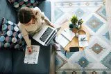 Woman working on a laptop with LinkedIn marketing notes and stationery.