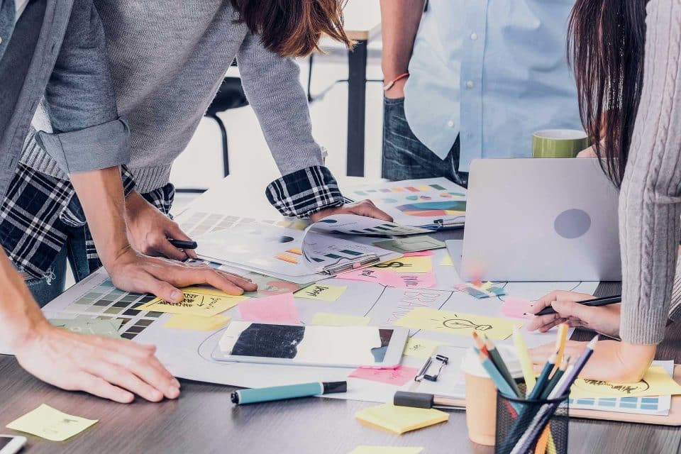 Rebranding efforts underway as people collaborate over notes and swatches.