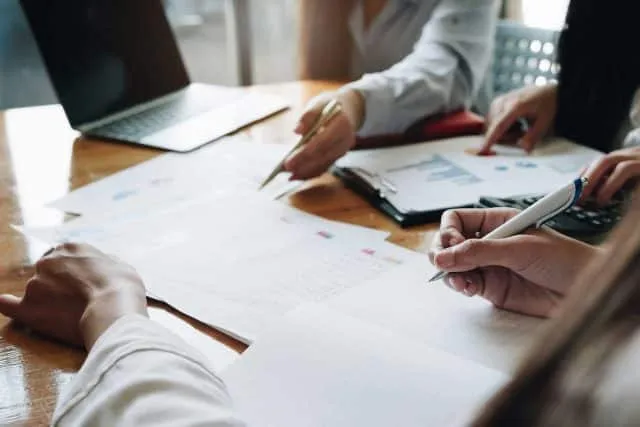 Community Insurance Partners reviewing documents and graphs at a wooden table.