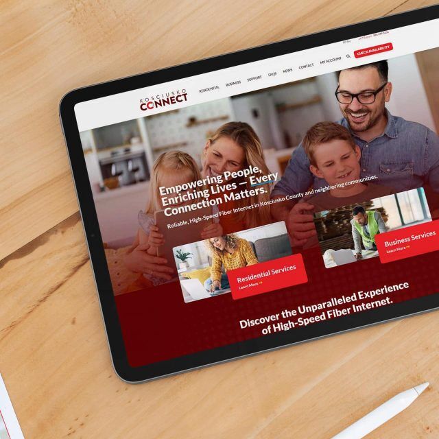 Tablet showing Kosciusko Connects high-speed internet site on a wooden table.