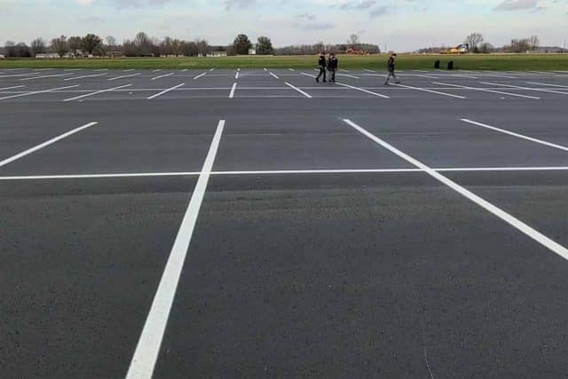 Empty parking lot with a few people and a Super Seal sign in the distance.