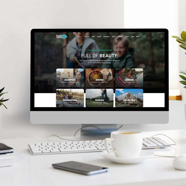 Computer displaying a nature-themed site, on a Fulton County desk.