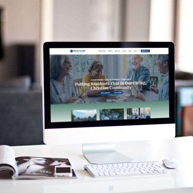 Grace Village: Computer displays website with people meeting image.