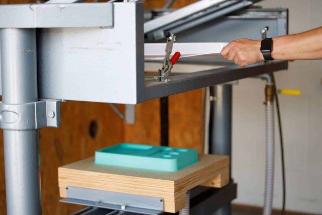 Person operating an OsteoShape paper cutting machine in a workshop.