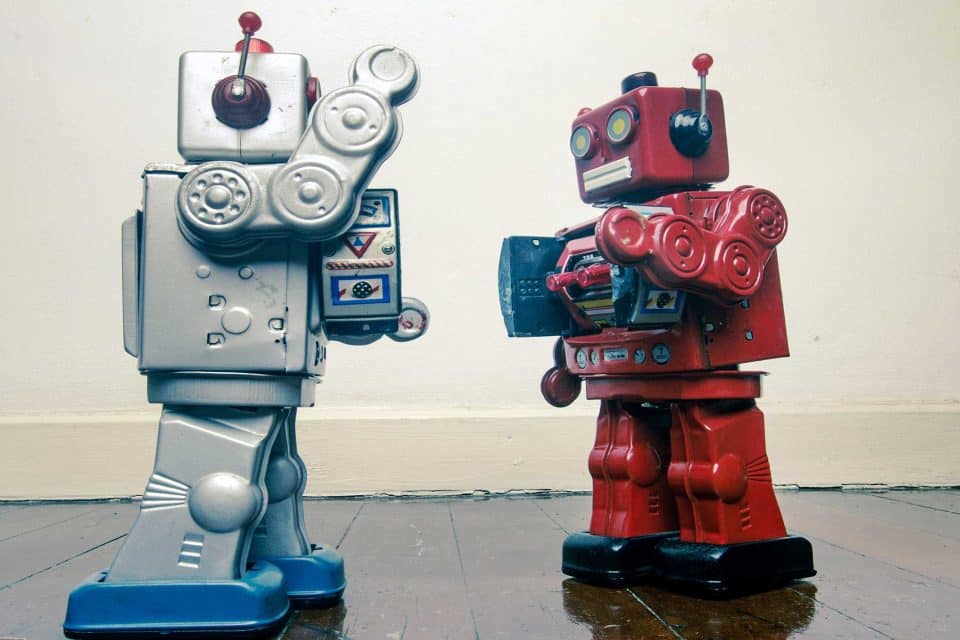 Two vintage toy robots in a standoff, like mail marketing rivals.