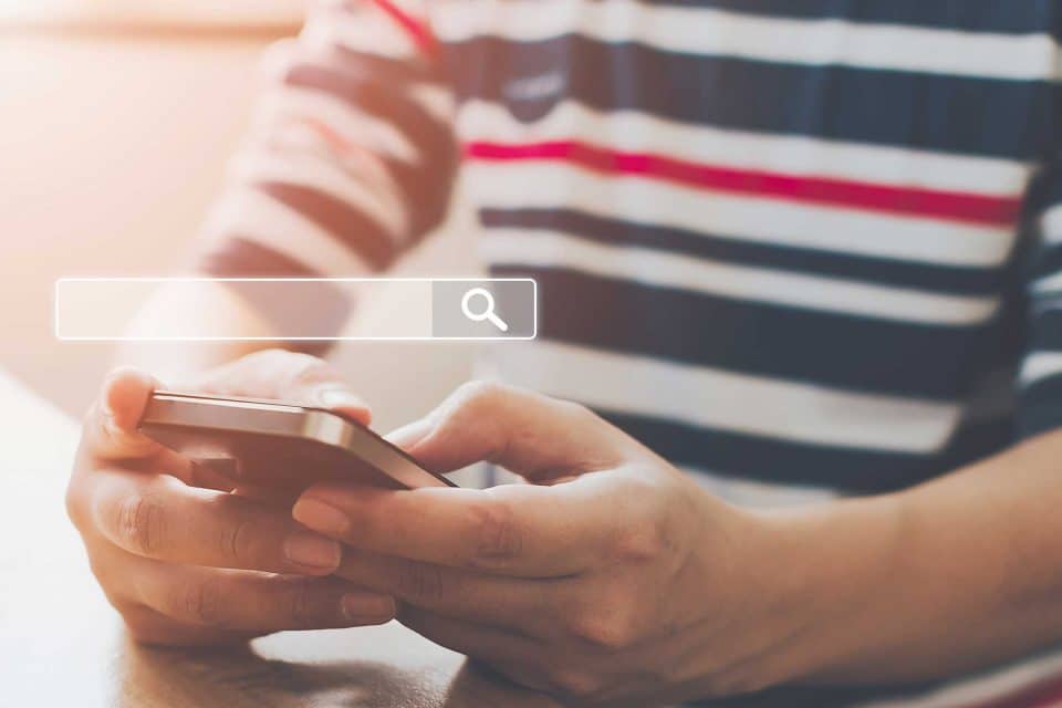 Person using a smartphone for SEO insights during COVID-19.