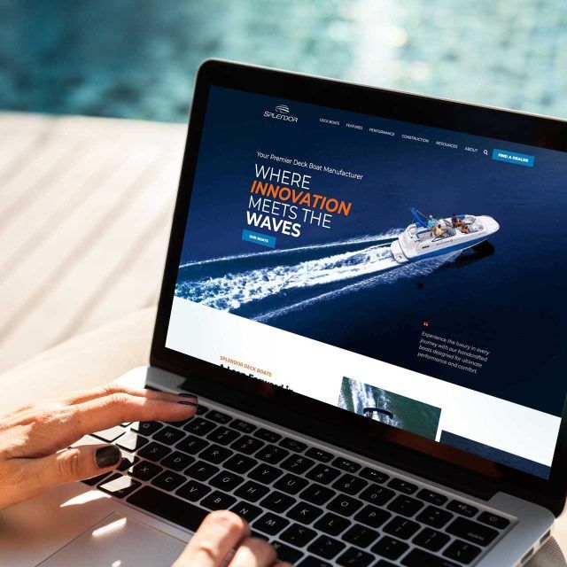 A Splendor Boats website is displayed on a laptop near the pool.