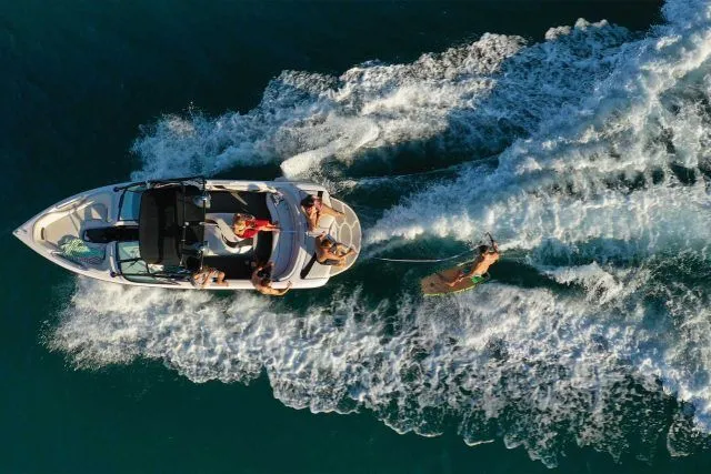 Splendor Boats towing a wakeboarder on a sunny day in clear waters.