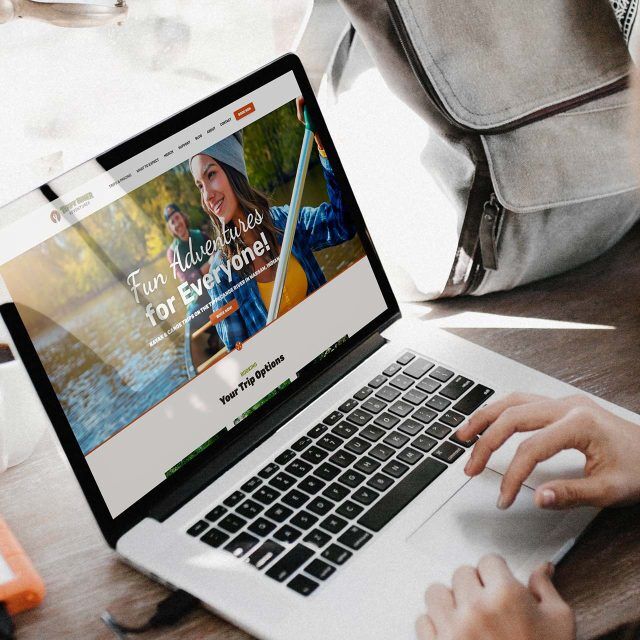 Person using a laptop showing Tippy River adventures website.