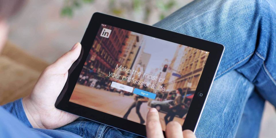 Person holding a tablet with LinkedIn login on the social media platform.