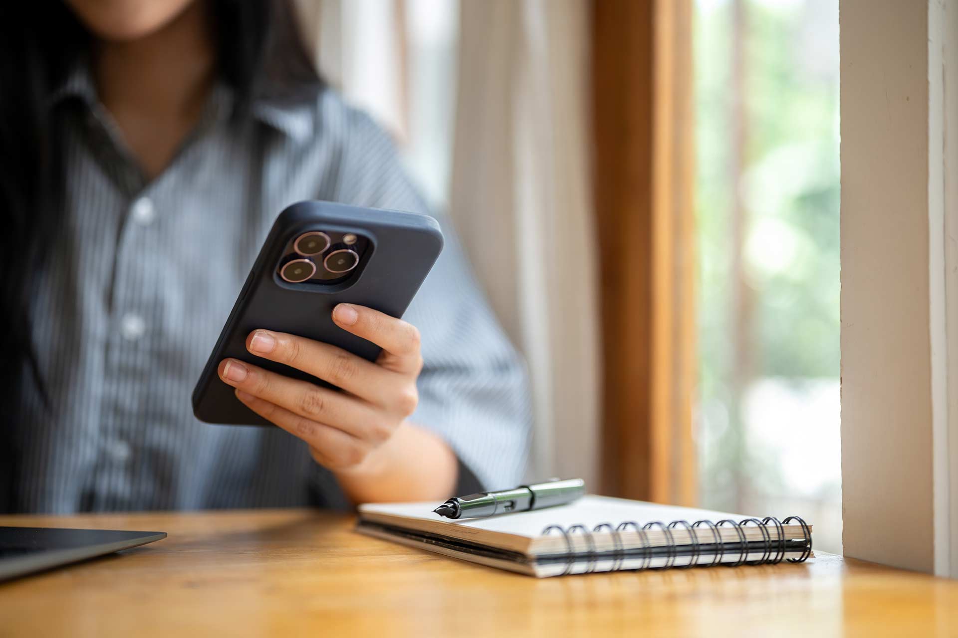 Person with smartphone, notebook, and a content style guide for businesses.