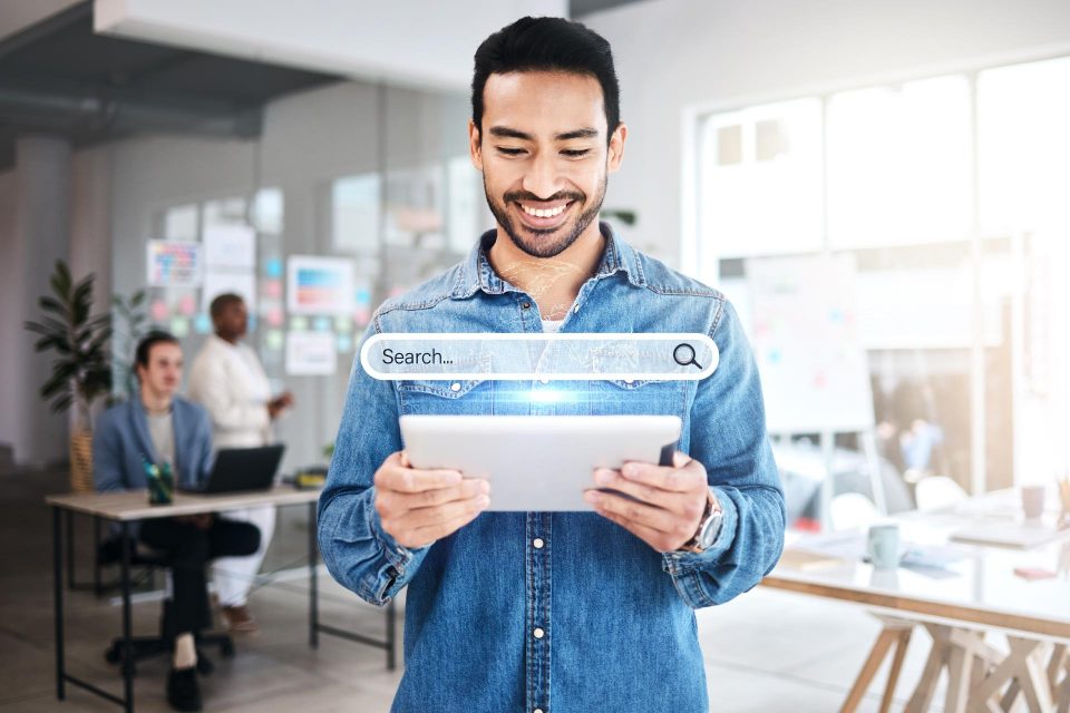 Man using a tablet in an office, highlighting mobile-first design and search.