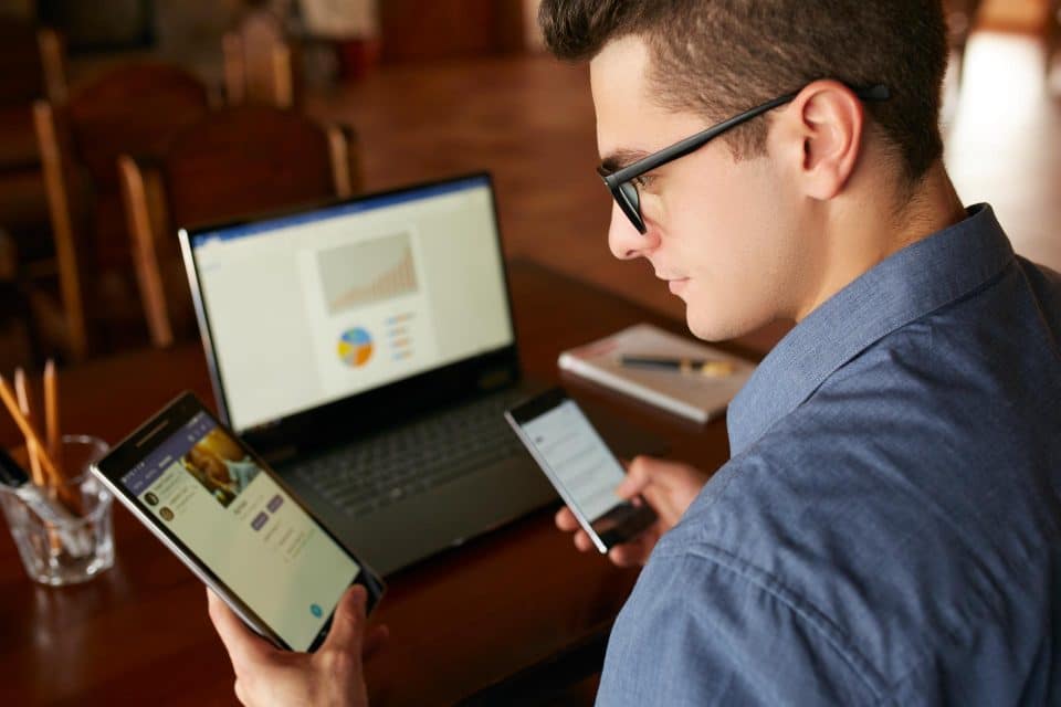 Man works at a desk, managing devices for seamless omnichannel marketing.