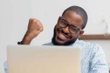 Person smiling and fist pumping after digital marketing services success.