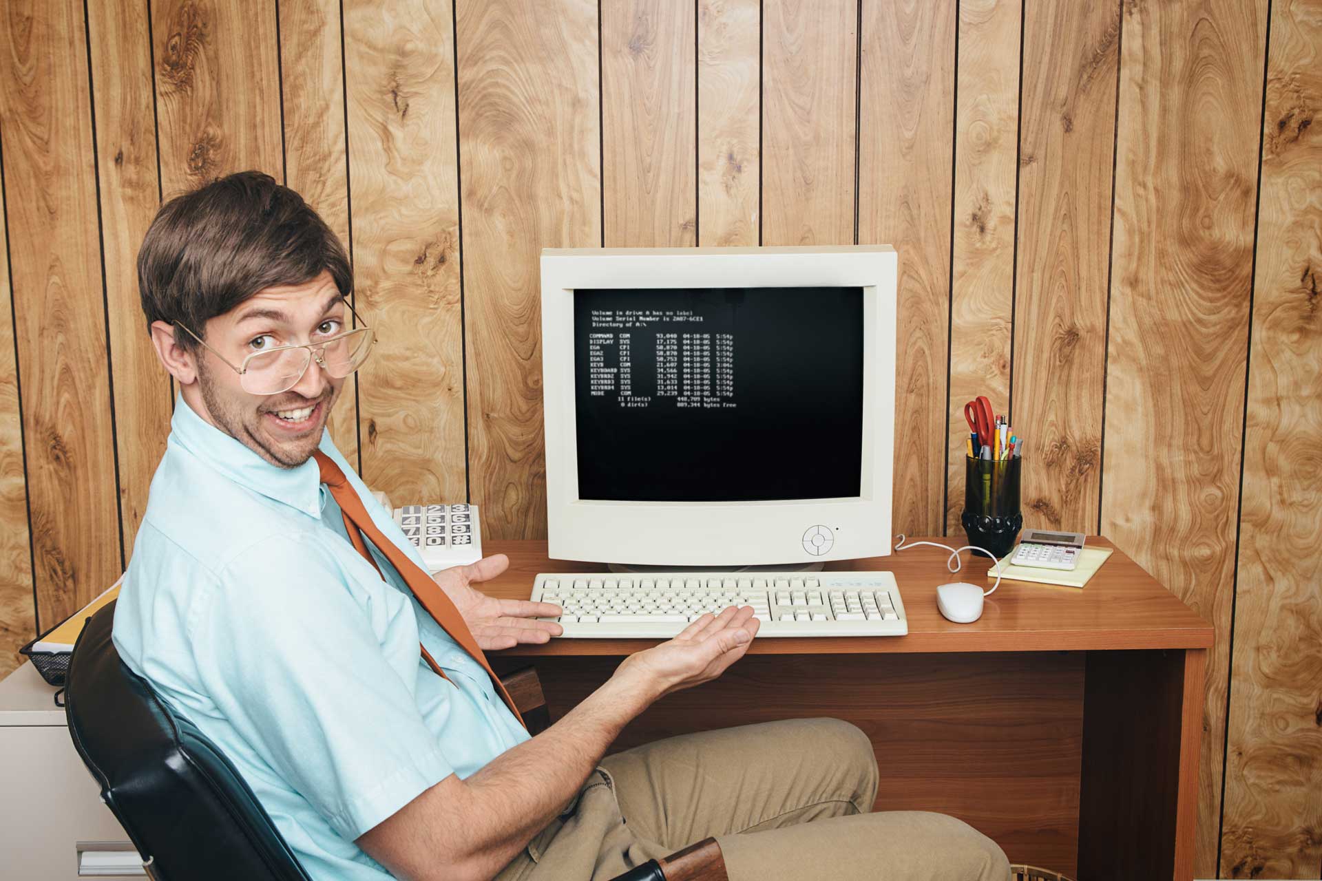 Person in an office pointing at a vintage computer screen displaying FLOW.