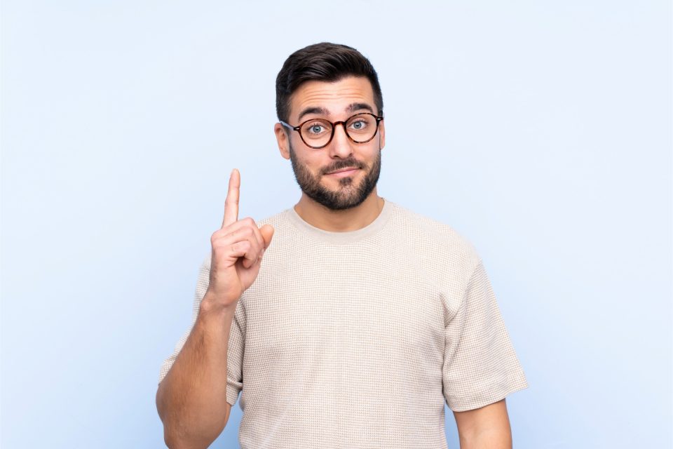 A man with glasses pointing up, standing against a Google Business Profile backdrop.