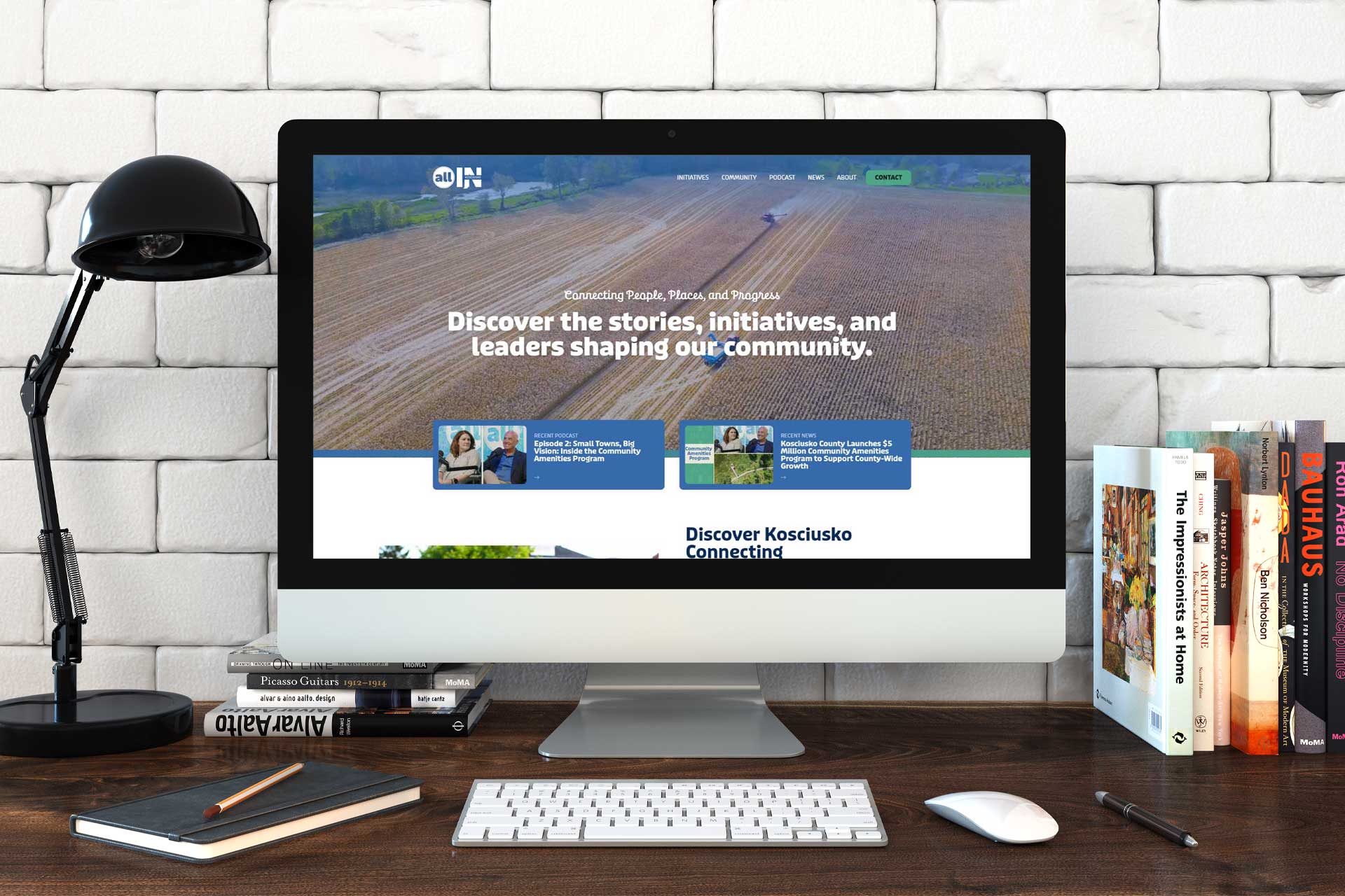 Computer on a desk displays a website about community stories and initiatives.