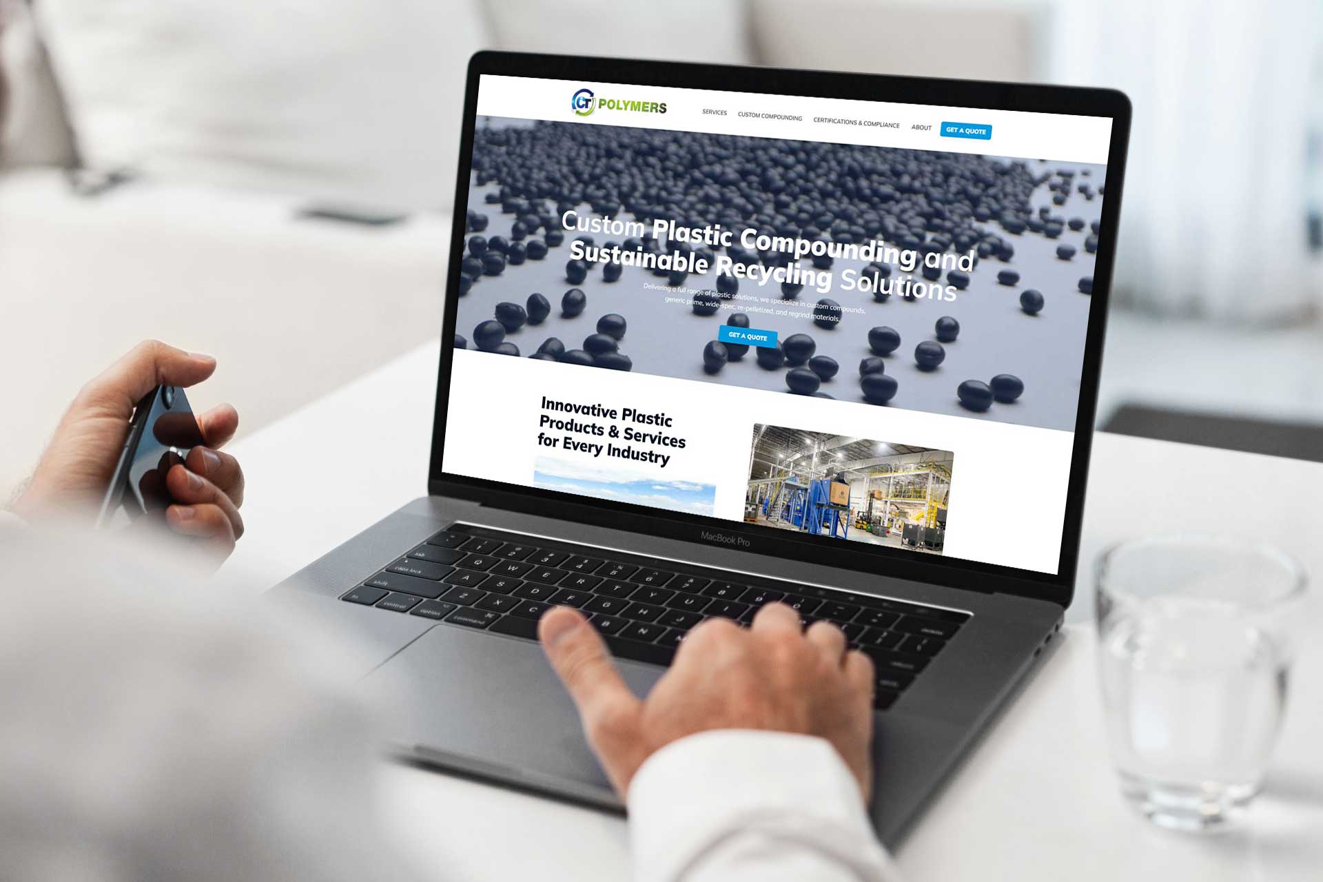 Person using a laptop displaying a plastics company’s website on the screen.
