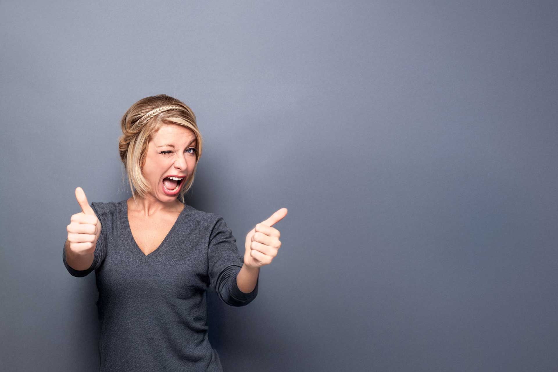 Person in gray shirt giving a double thumbs up with a brand consulting wink.
