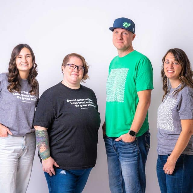 Four people standing, embodying brand consulting, against a plain background.