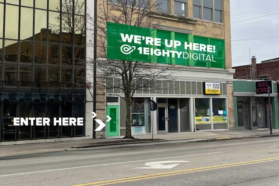 Street view with sign pointing to 1Eighty Digitals entrance. Contact us!.