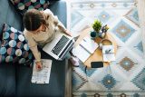 Woman working on a laptop with LinkedIn marketing notes and stationery.