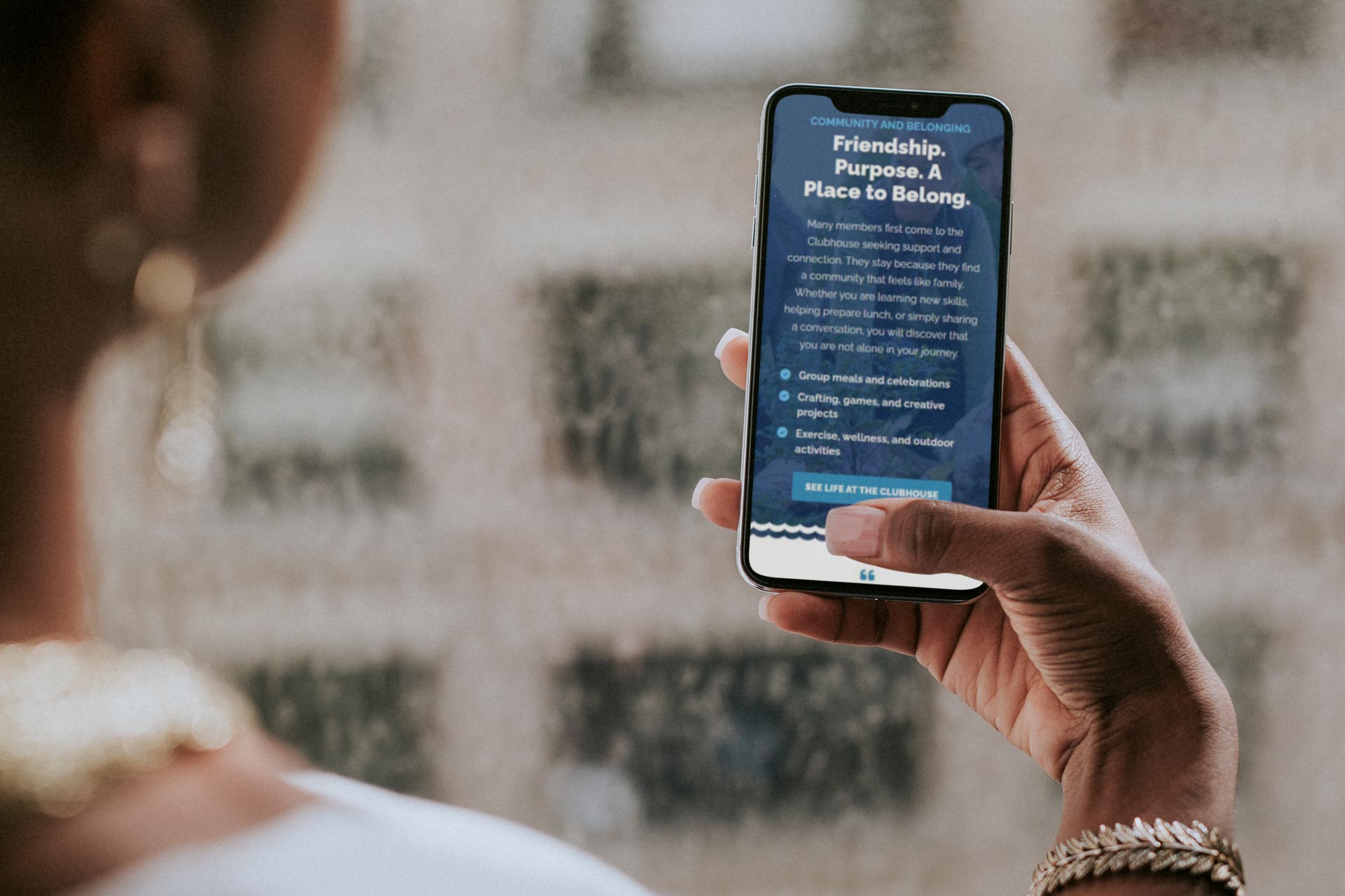 Person holding a smartphone displaying text about friendship and community.
