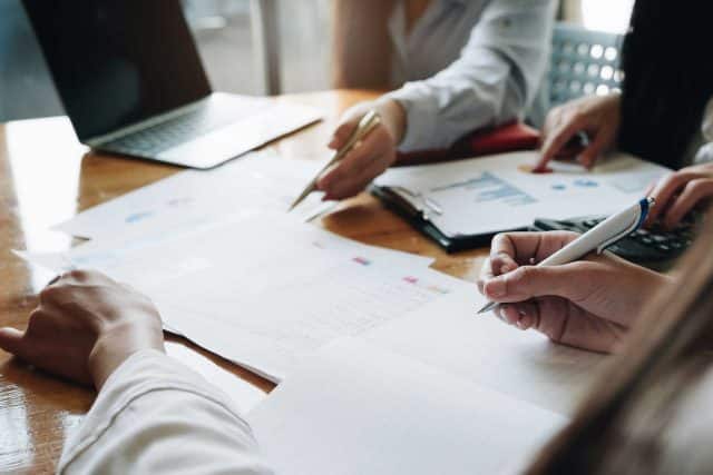 Community Insurance Partners reviewing documents and graphs at a wooden table.