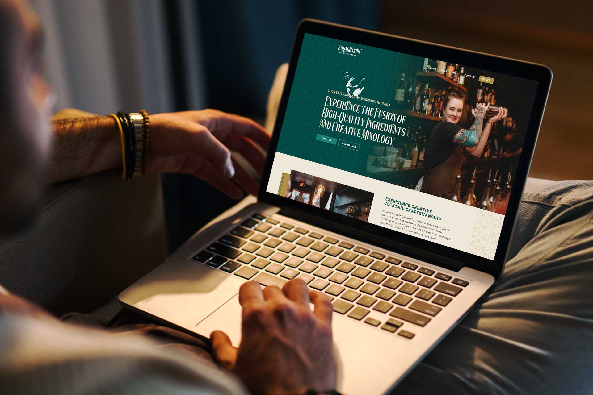 Person browsing Falling Rabbit Cocktail Lounges website on a laptop.