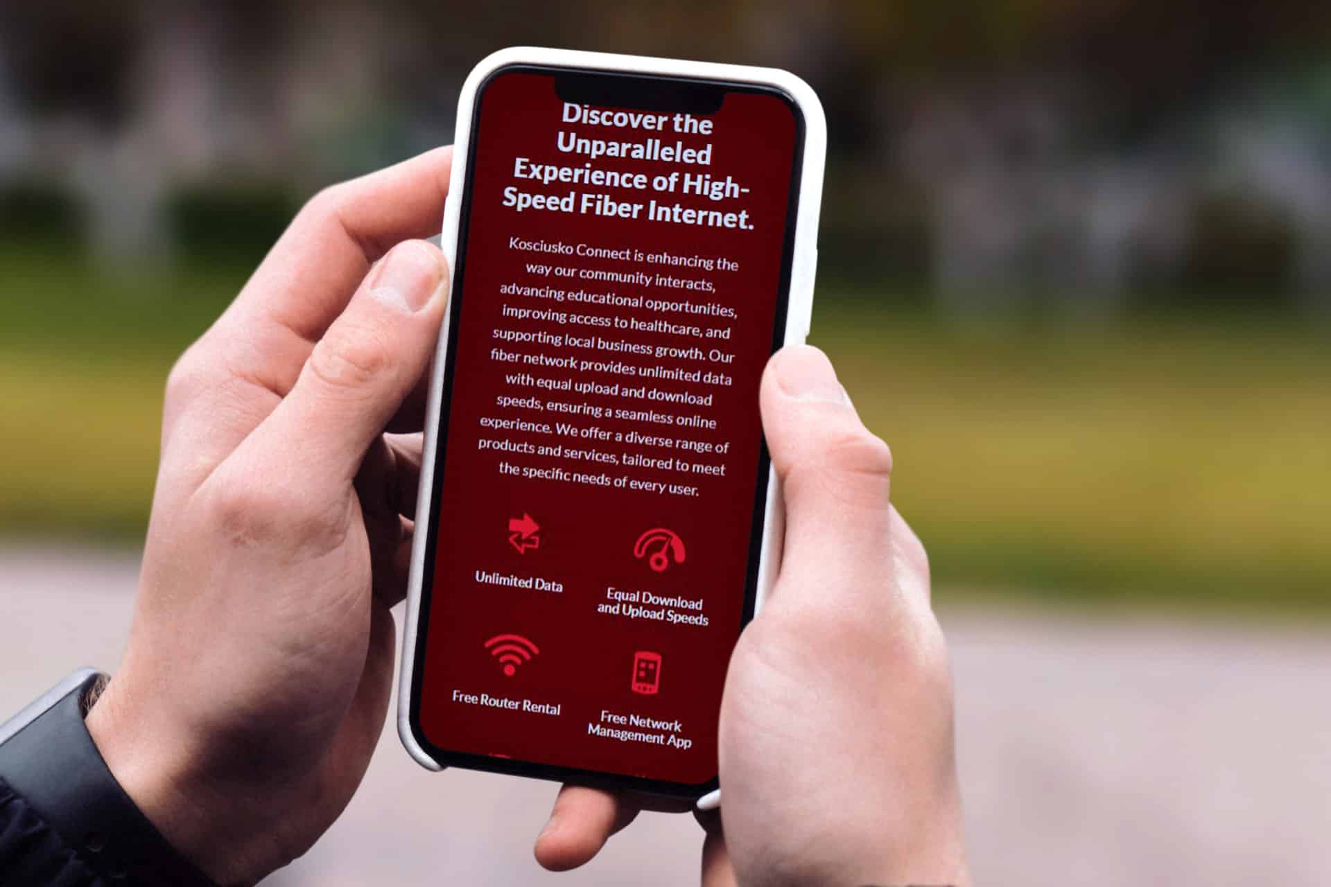 Person with phone showcasing Kosciusko Connects internet service ad.