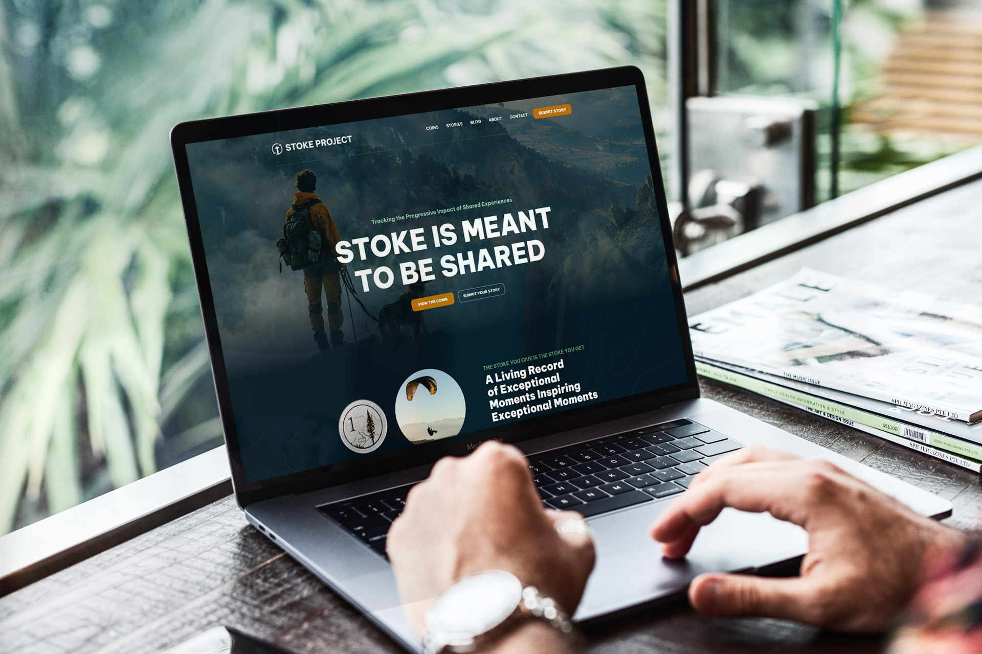 Person using a laptop displaying a website with the text STOKE IS MEANT TO BE SHARED.