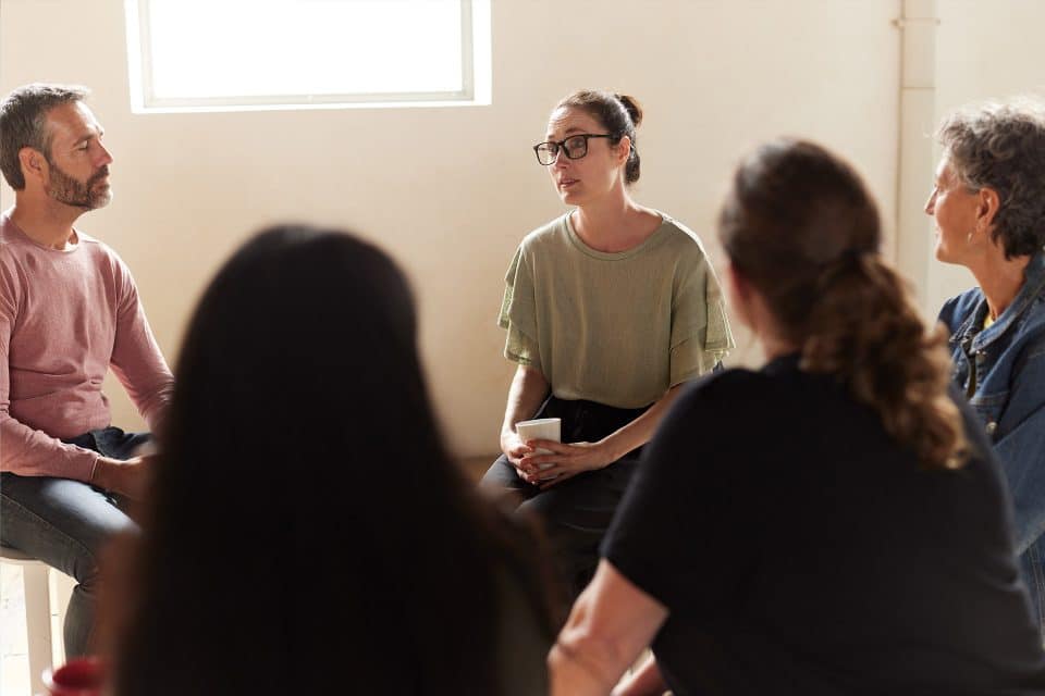 Four people in fellowship, engaged in a group discussion.