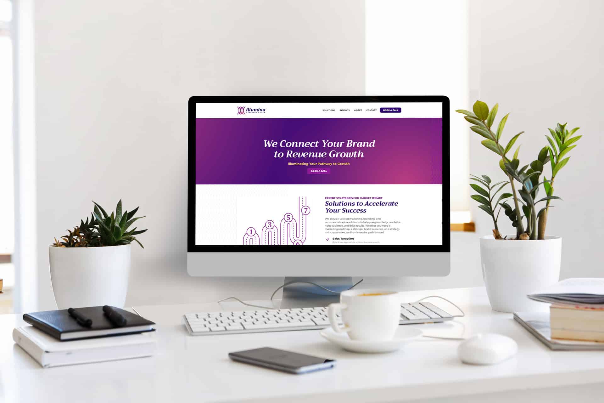 Computer monitor on a white desk displaying a business website, with plants nearby.