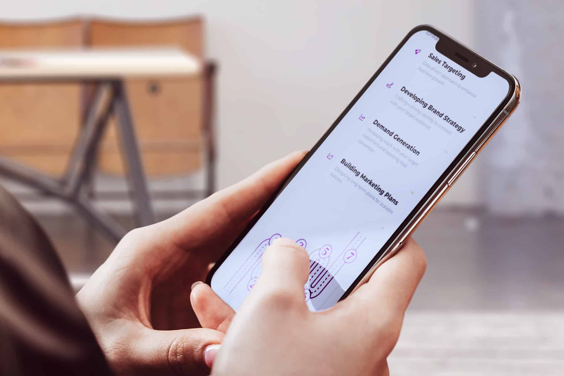 Person holding a smartphone displaying a marketing strategy checklist on screen.