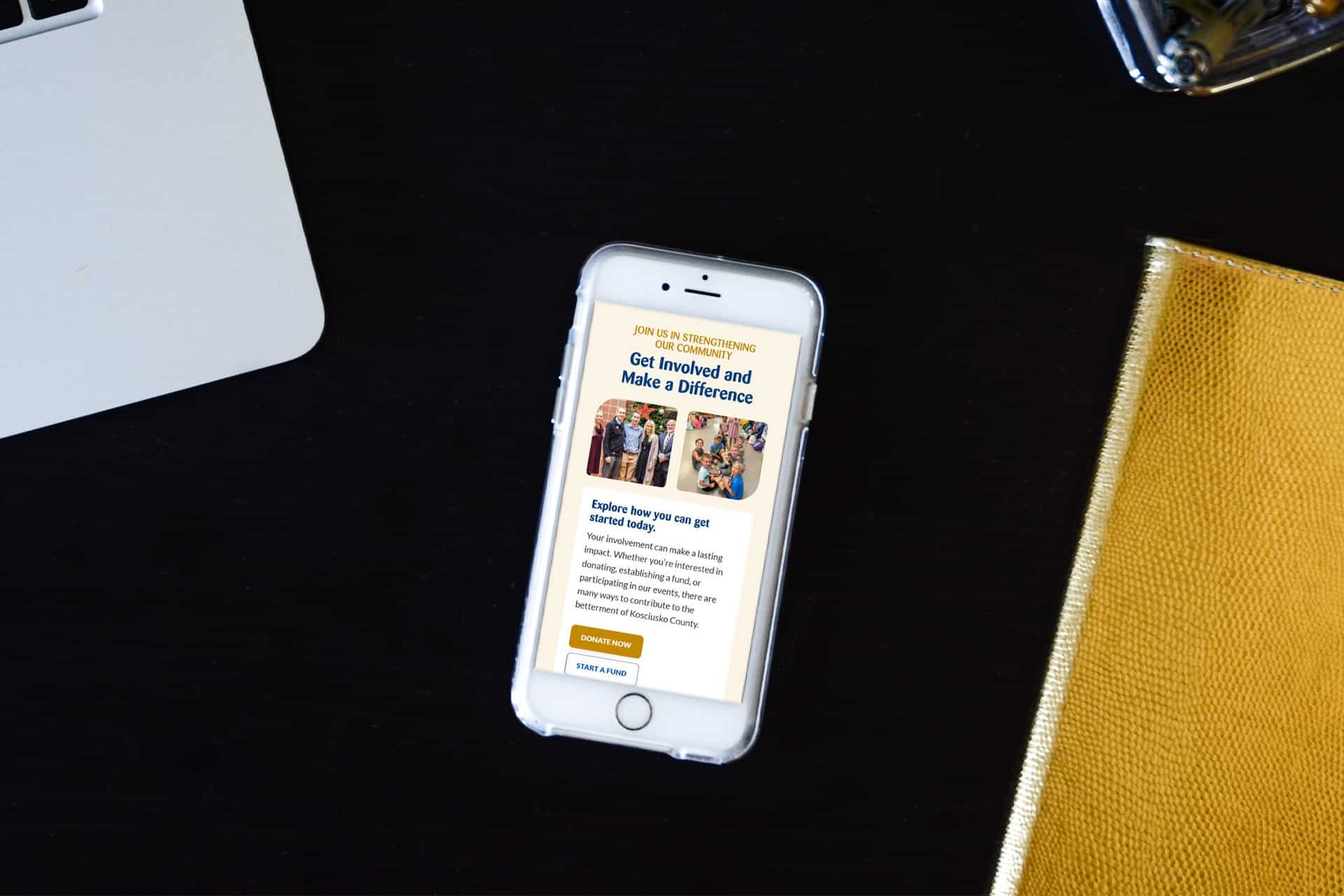 Phone on table shows Kosciusko County Community Foundation webpage.