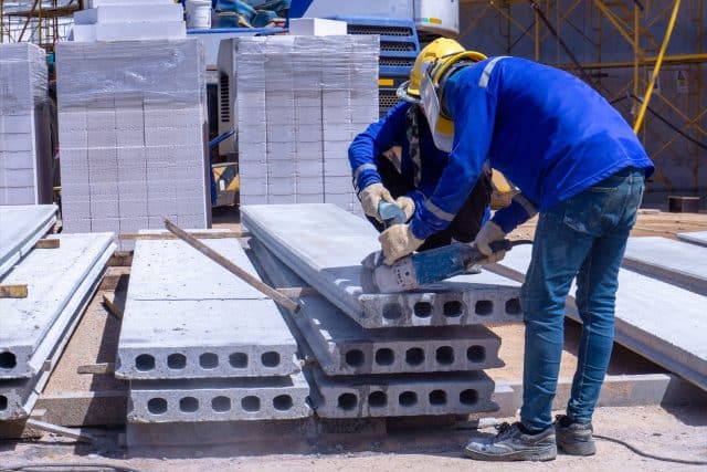 Workers in StresCore gear cutting concrete slabs at a construction site.