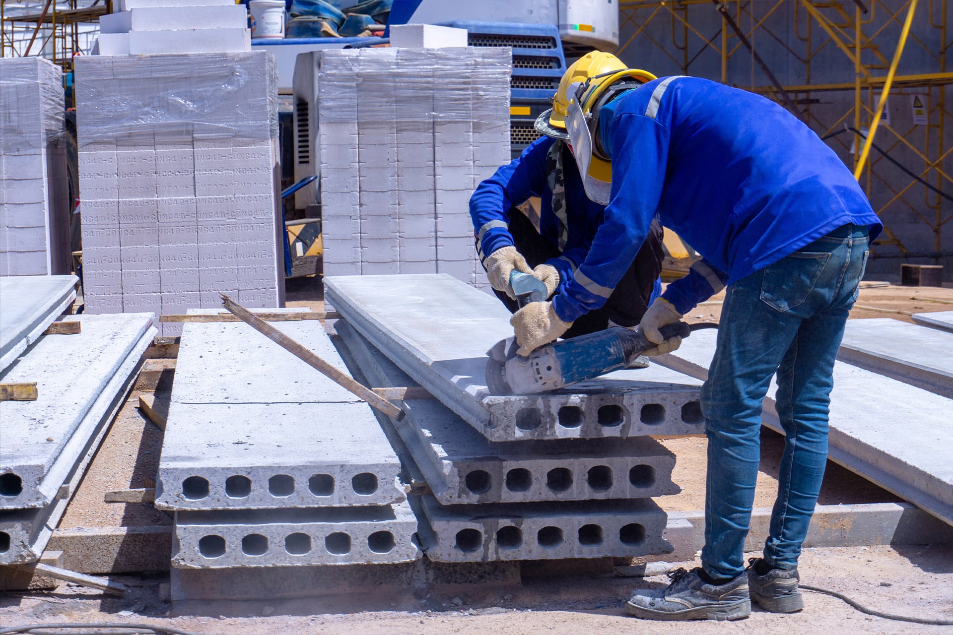 Workers in StresCore gear cutting concrete slabs at a construction site.