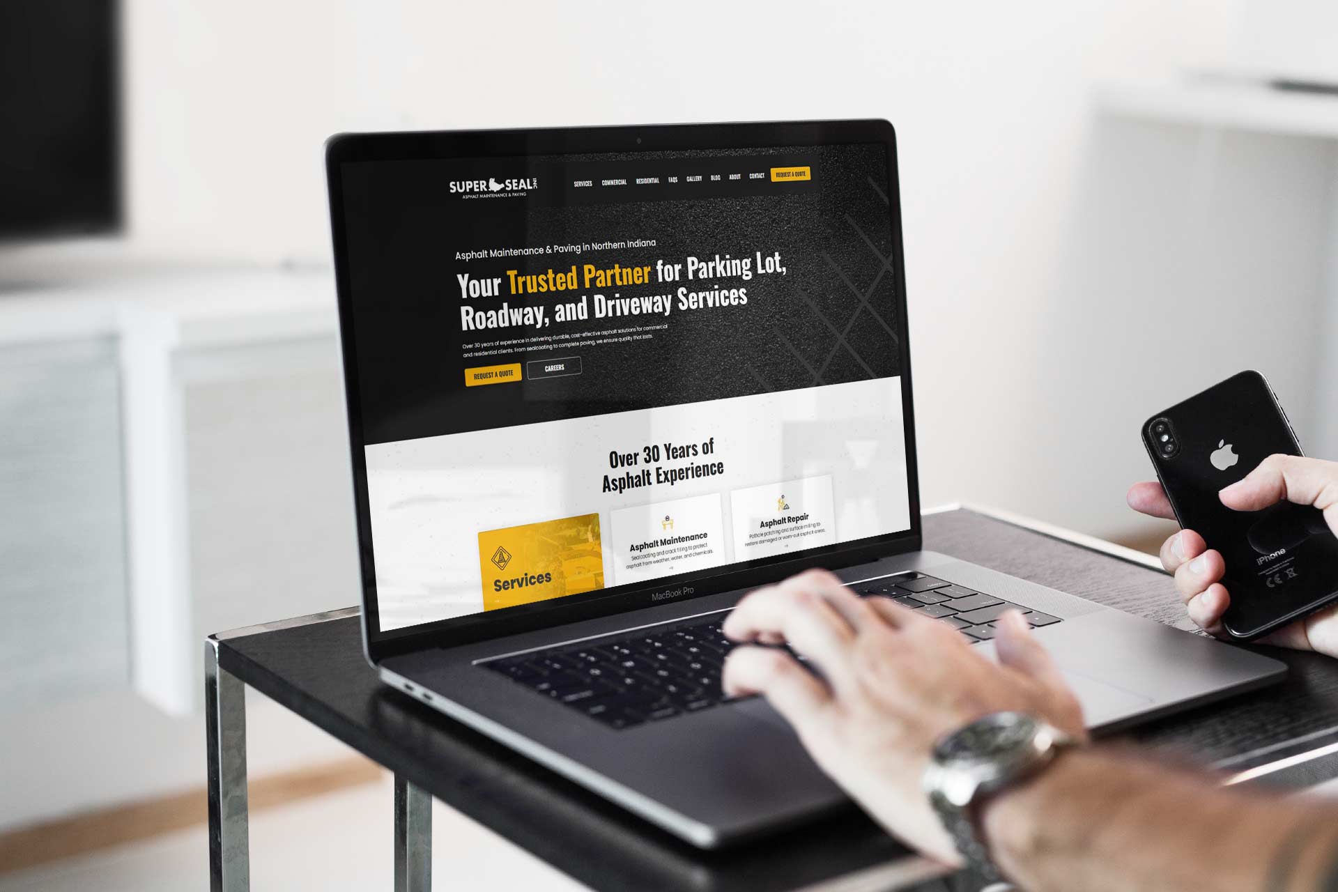 Person using a laptop viewing Super Seals asphalt services website.
