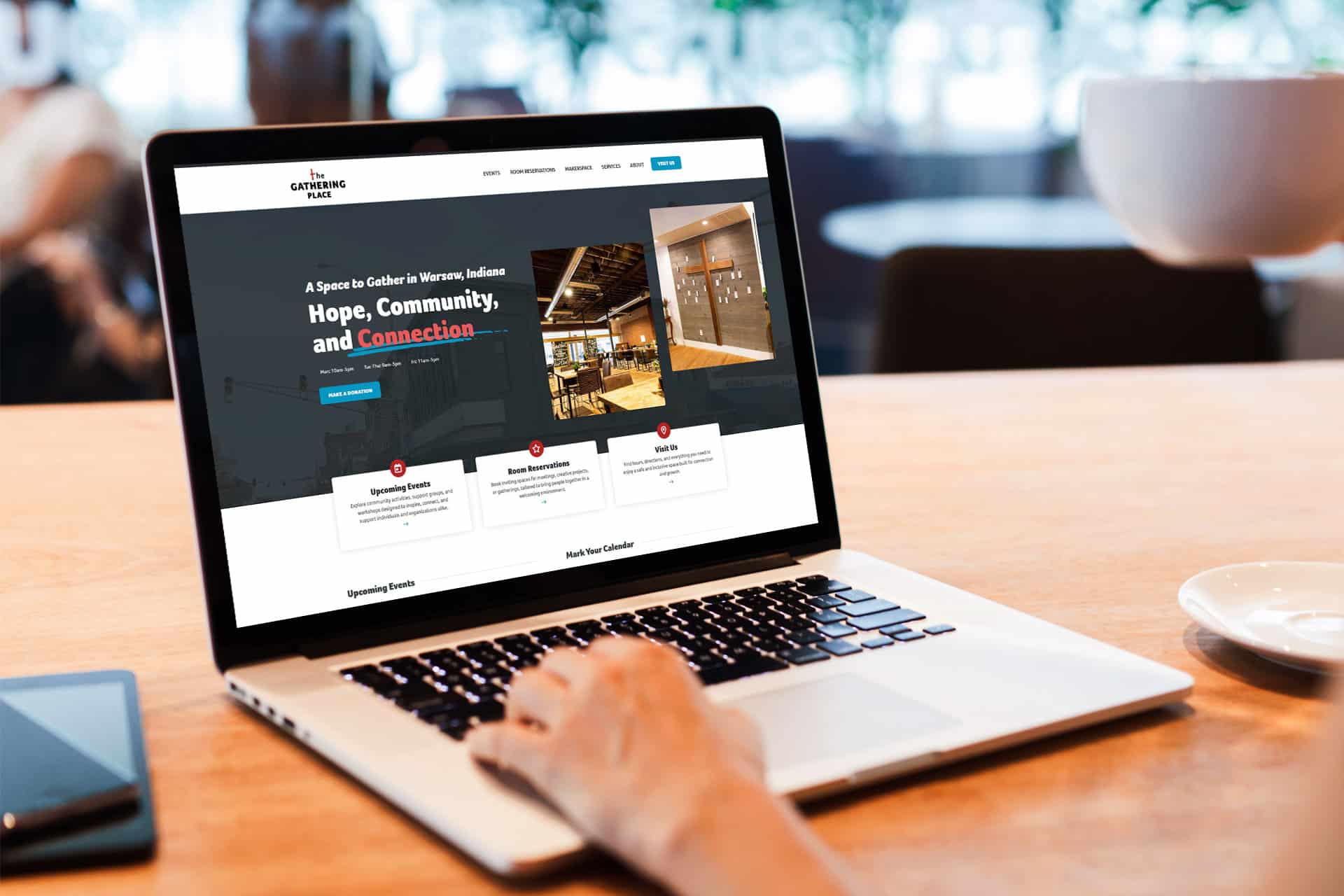 A person using a laptop at The Gathering Place with a website displayed.