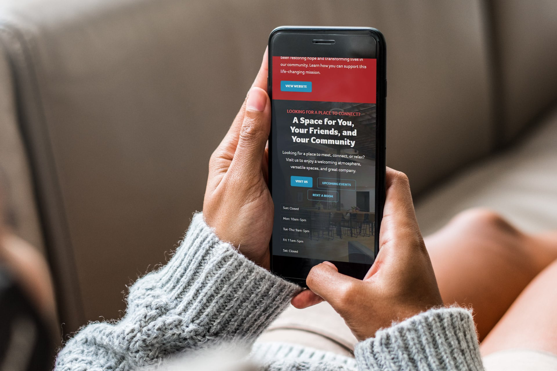 Person holding a smartphone showing The Gathering Place booking page.