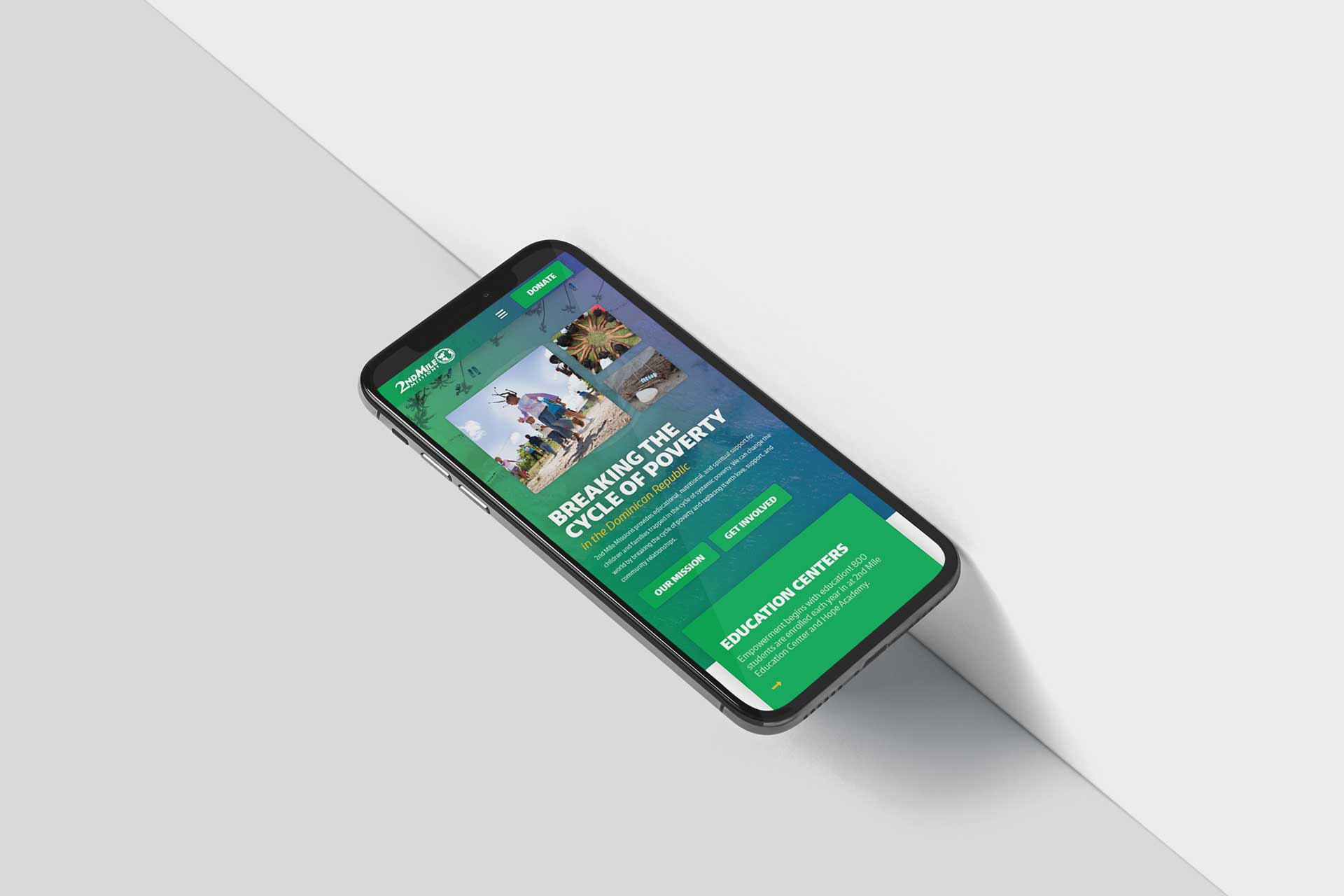 Smartphone showing 2nd Mile Missions site on poverty alleviation in green tones.
