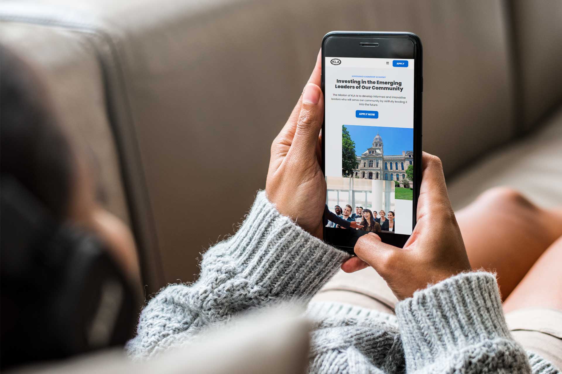 Person holding phone with Kosciusko Leadership Academys community site.