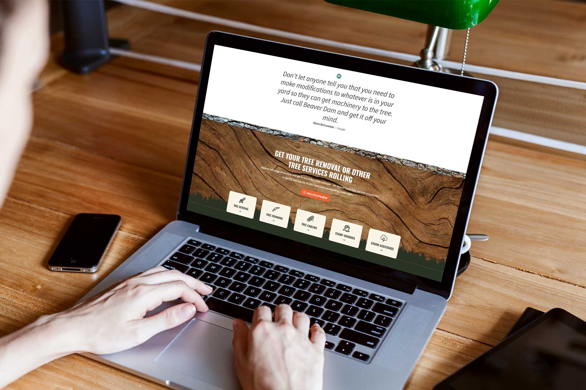 User browsing Beaver Dam Tree Service website on a laptop.