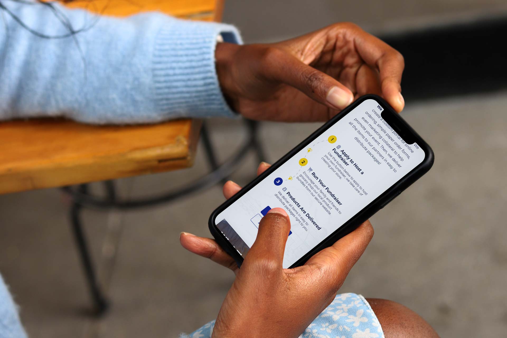 Person reading text on a smartphone in a blue barn, feeling relaxed.