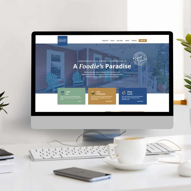 Computer on desk showing a website titled A Foodies Paradise.